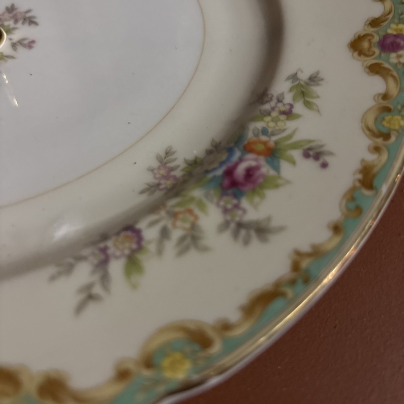 A three-tier porcelain cake stand with mismatched floral plates and gold trim. gallery