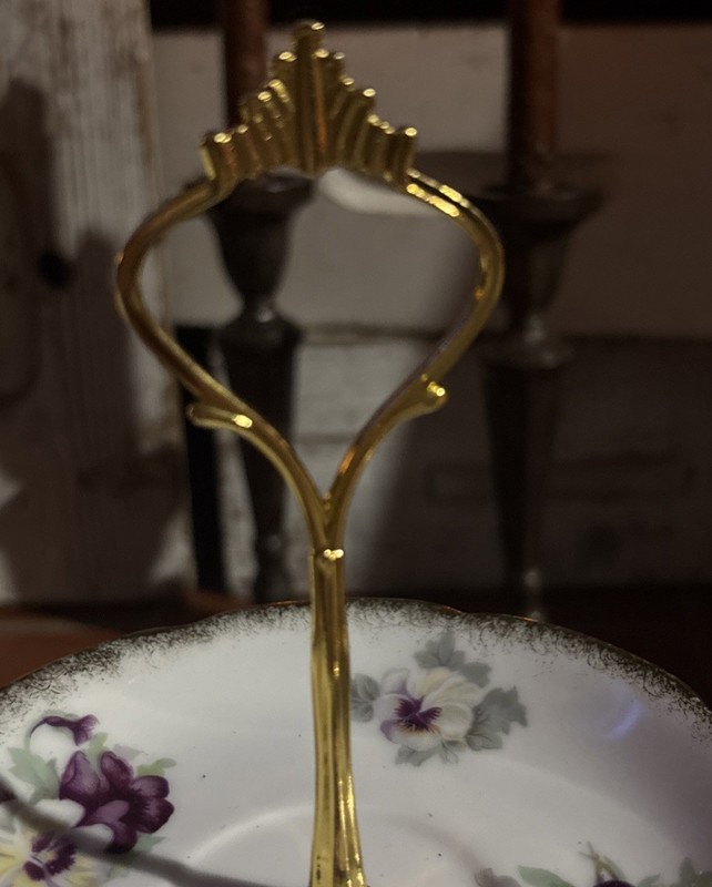 A three-tier porcelain cake stand with mismatched floral plates and gold trim. gallery