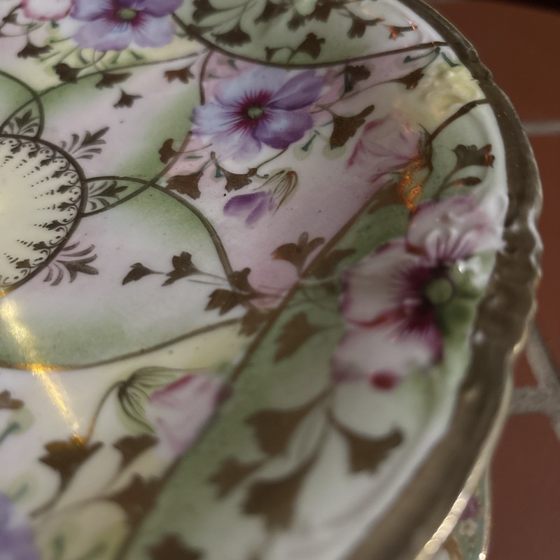A three-tier porcelain cake stand with mismatched floral plates and gold trim. gallery
